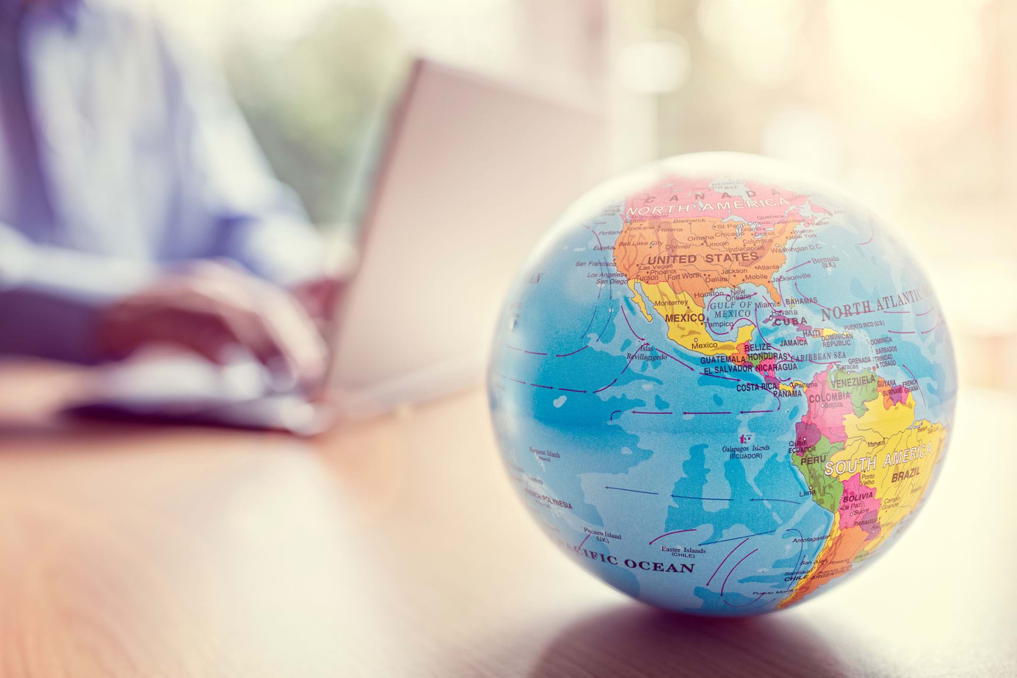 A globe in front of a laptop